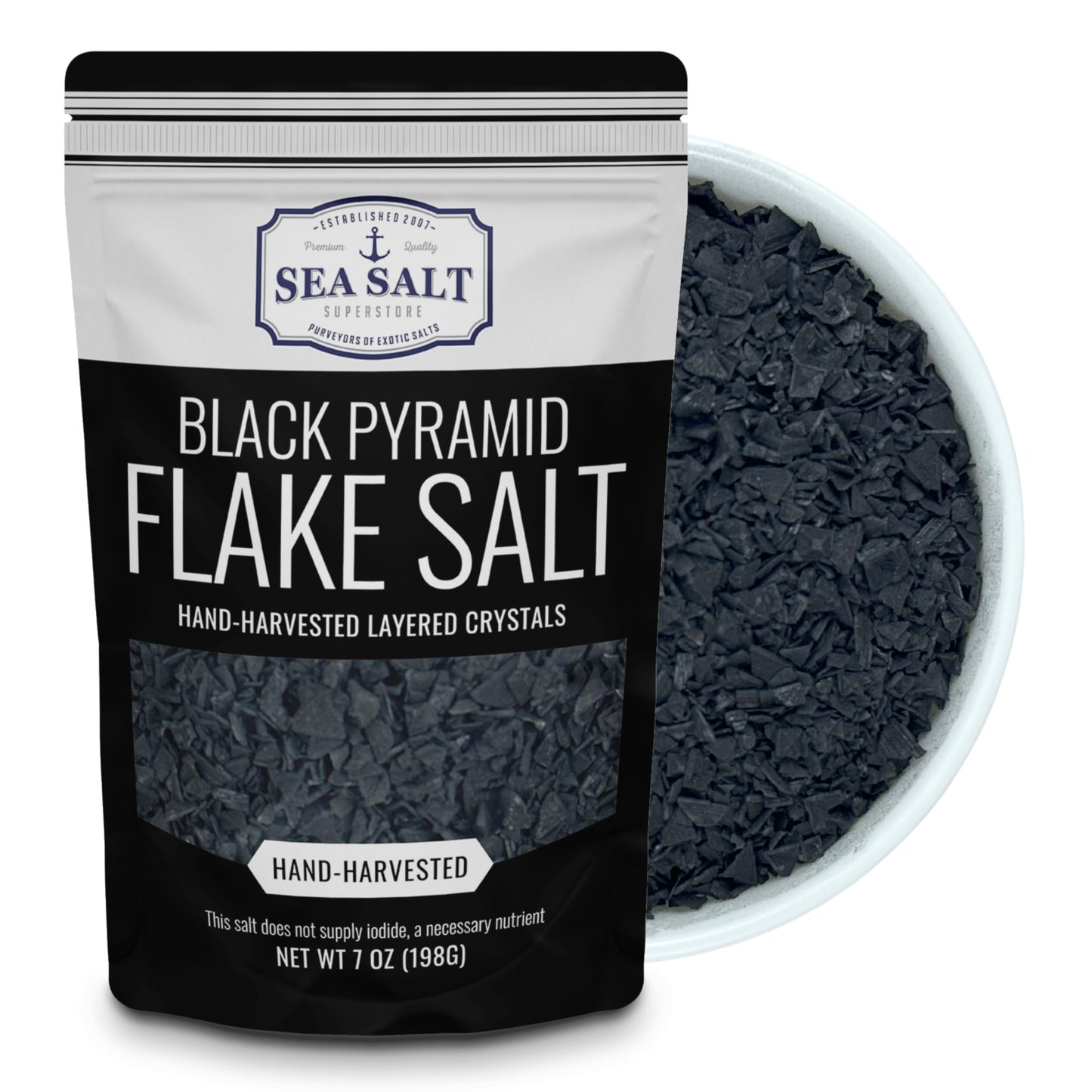 Black Pyramid Flake Salt - 7 oz Pouch in a bowl, showcasing its unique black color and flaky texture.