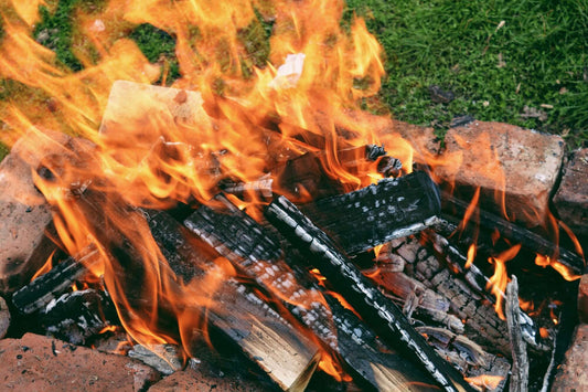 Firewood burning in a fire pit, demonstrating the smoky process for making The Best Smoked Salts: A Culinary Guide to Naturally Flavored Sea Salts.