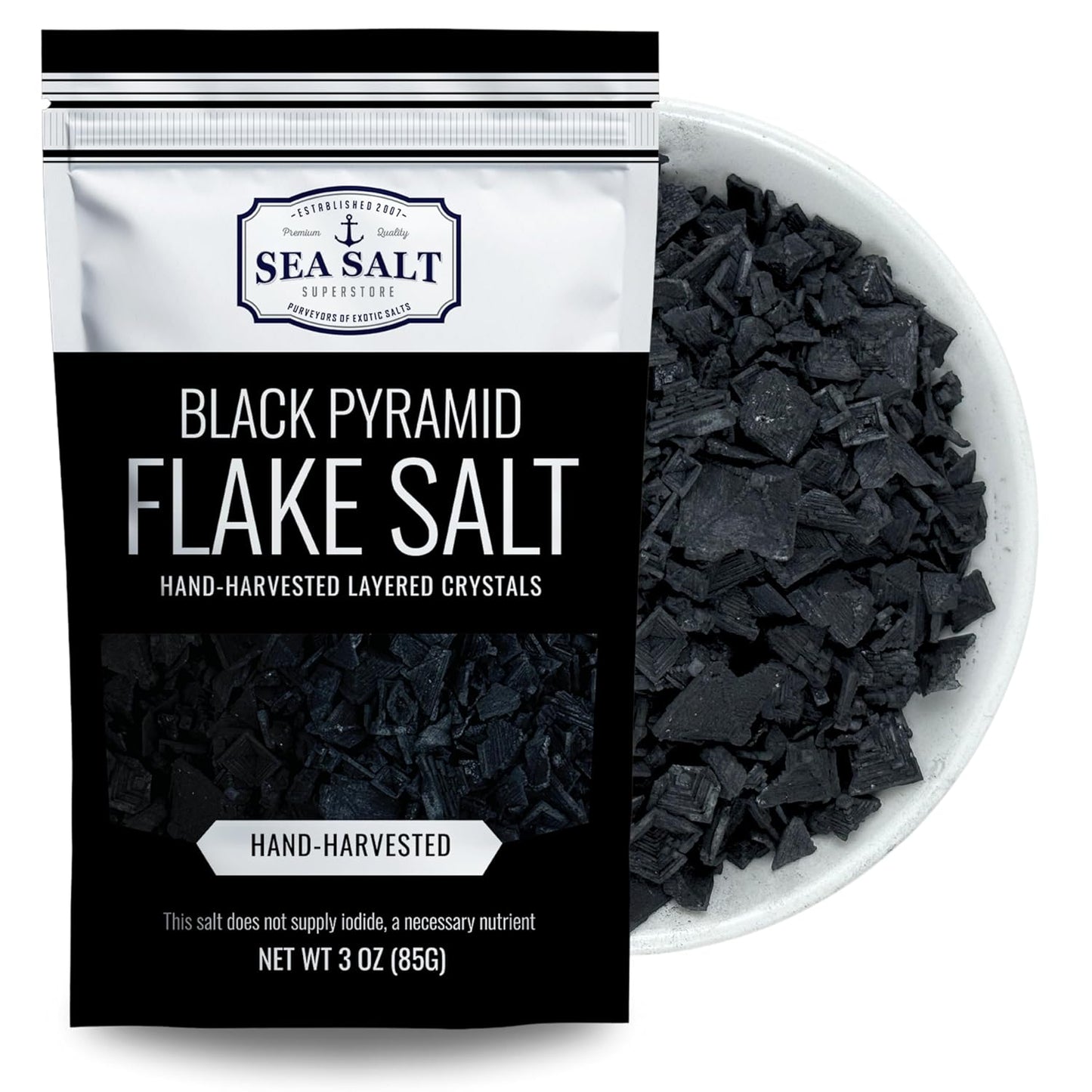 Black Pyramid Flake Sea Salt - 3 oz Pouch displayed in a bowl, showcasing its unique texture and color.
